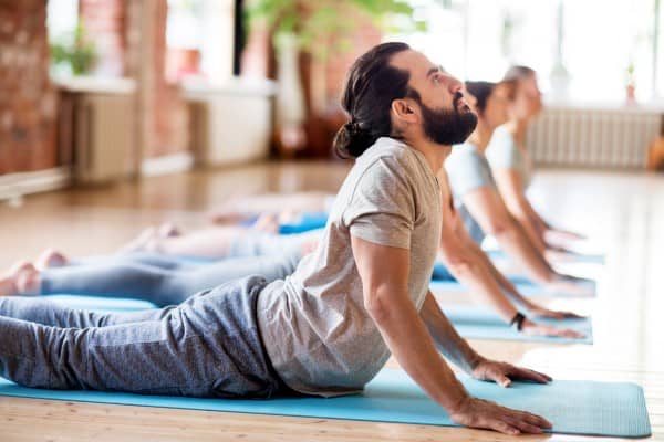 Rolfing Blick auf die Yoga PositionCobra - junger Mann in Yoga mit dem inneren Kampf der Öffnung im tiefen Hals Position die