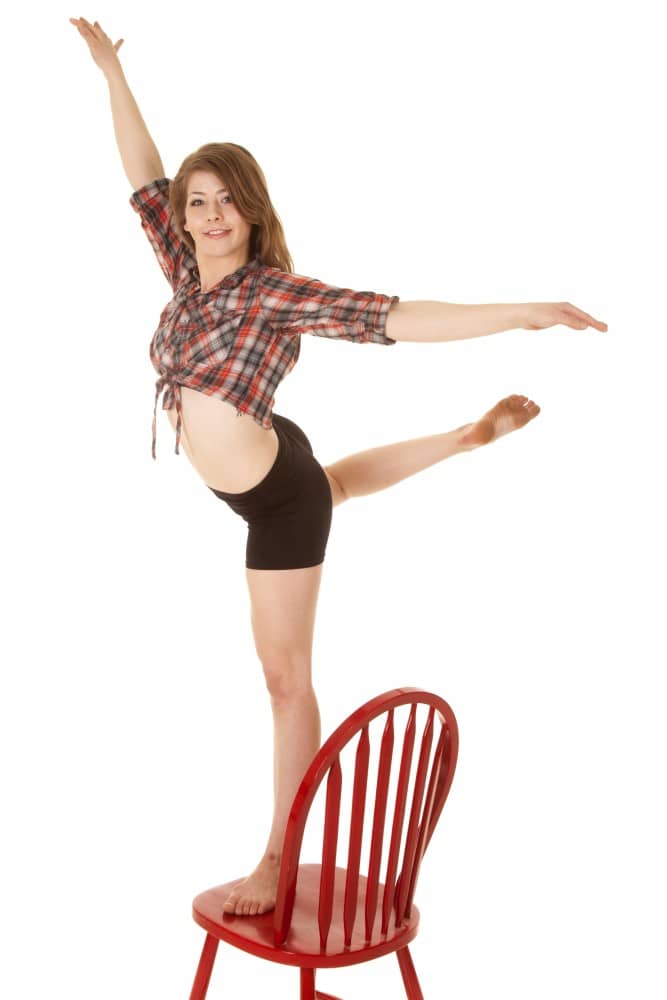 Junge Frau mit Raumorientierung auf einem Stuhl balancierend