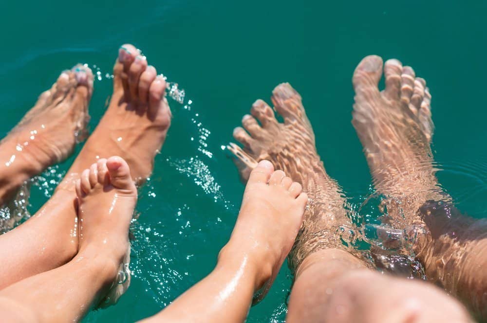 bewegliche Füße einer Familie im Wasser