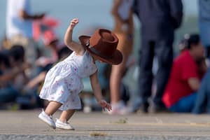 Kleines Mädchen kann wegen eines großen Hutes nicht sehen und stürzt auf die Hände 1